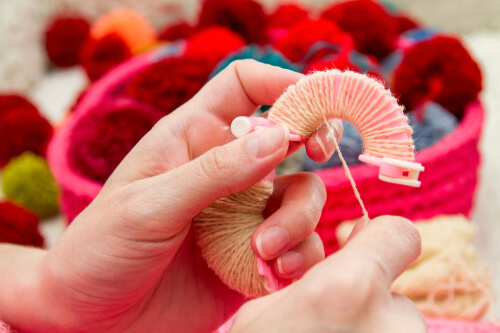 Cómo hacer pompones de hilo usando un fabricante de pompones